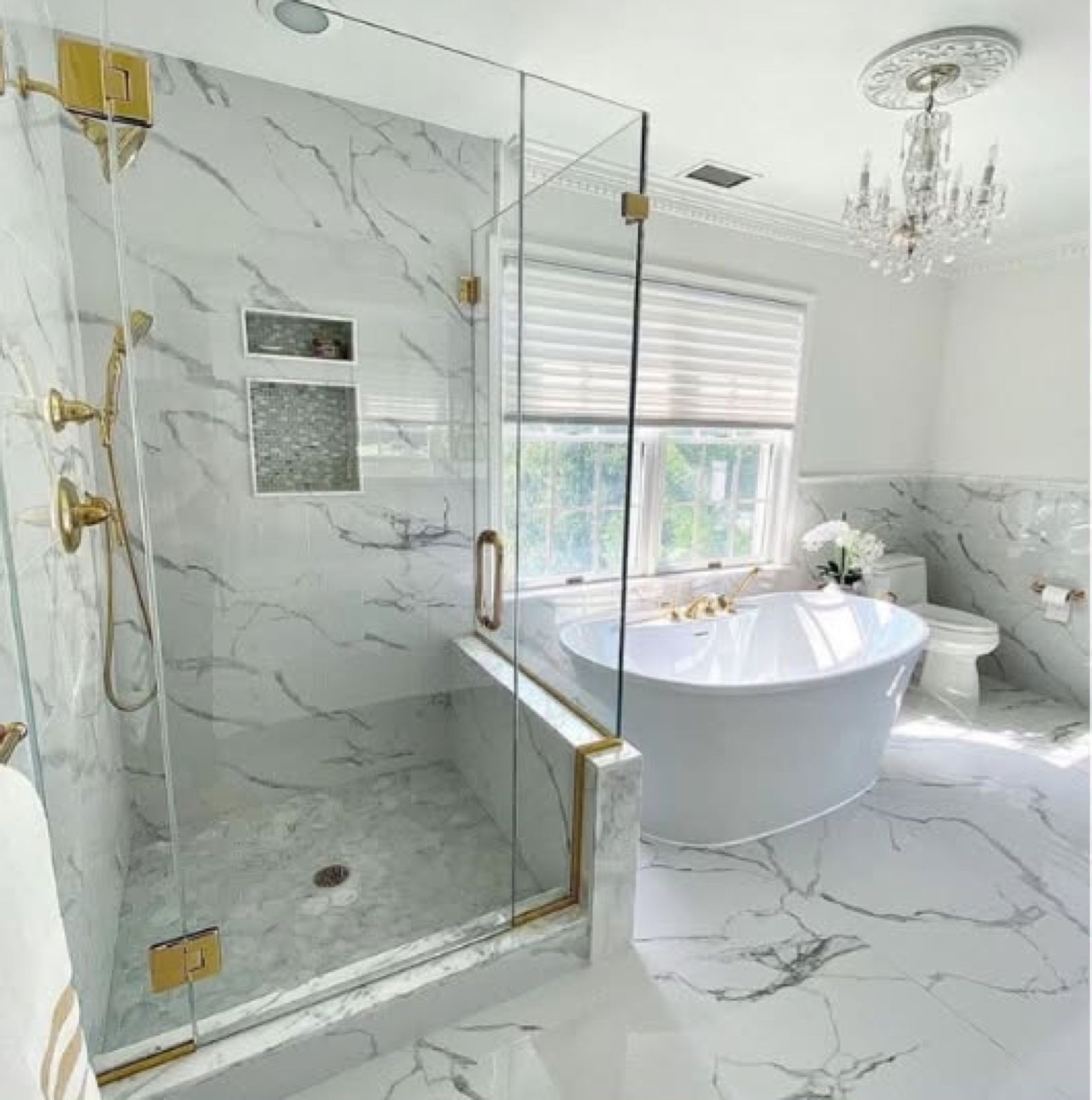 Luxury marble bathroom remodel with glass walk-in shower, gold fixtures and freestanding soaking tub