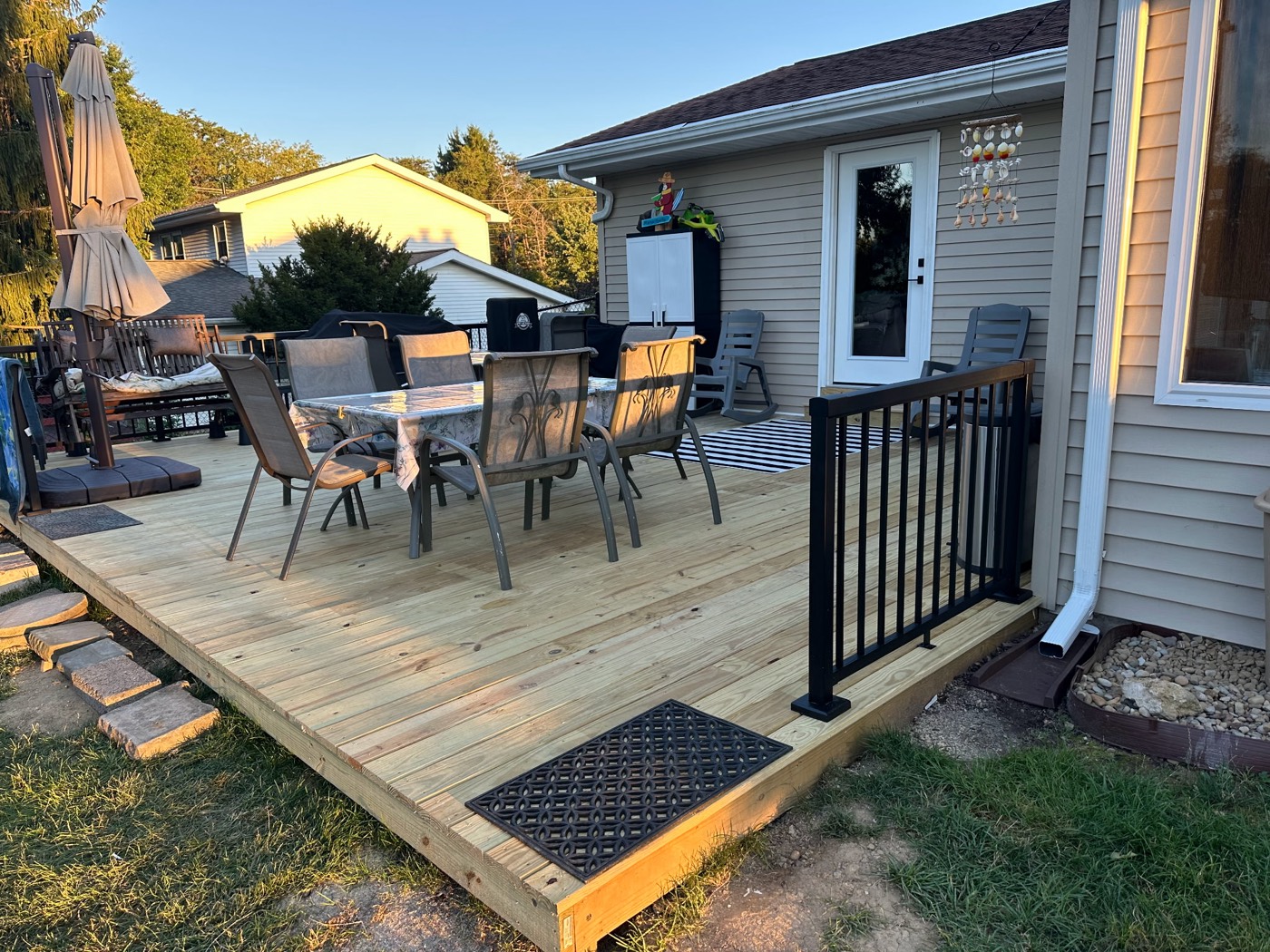 New pressure-treated deck with black aluminum railing and outdoor dining area