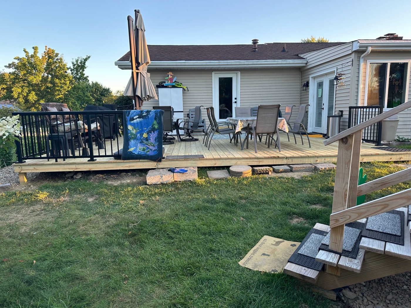 Full-width backyard deck addition with black aluminum railings